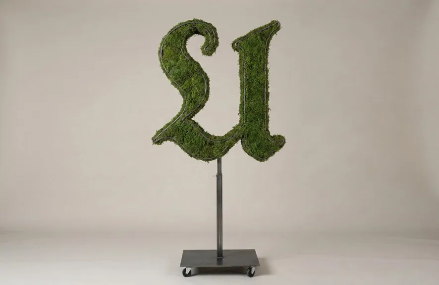 Monogram letter U topiary in Custom style, packed with green moss, on an adjustable stand