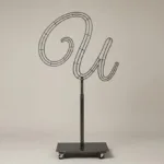 Monogram letter U topiary frame in Flowing script style, bare galvanized steel on an adjustable stand
