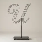 Monogram letter U topiary frame in Script style, bare galvanized steel on an adjustable stand