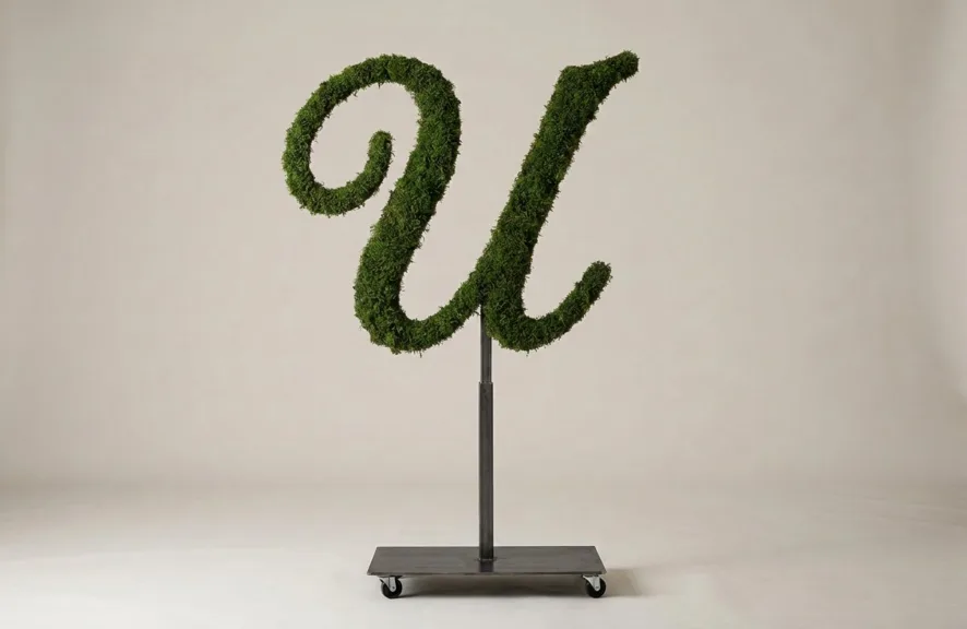 Monogram letter U topiary in Script style, packed with green moss, on an adjustable stand