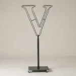 Monogram letter V topiary frame in Cinzel style, bare galvanized steel on an adjustable stand