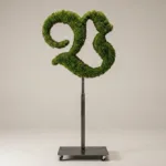 Monogram letter V topiary in Custom style, packed with green moss, on an adjustable stand