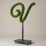 Monogram letter V topiary in Flowing script style, packed with green moss, on an adjustable stand