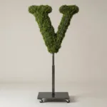 Monogram letter V topiary in Roman style, packed with green moss, on an adjustable stand