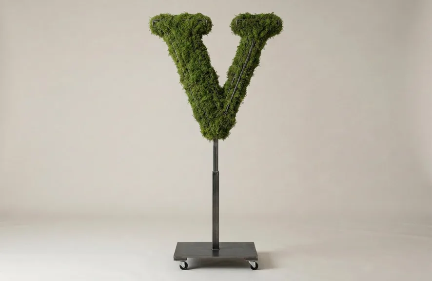 Monogram letter V topiary in Roman style, packed with green moss, on an adjustable stand