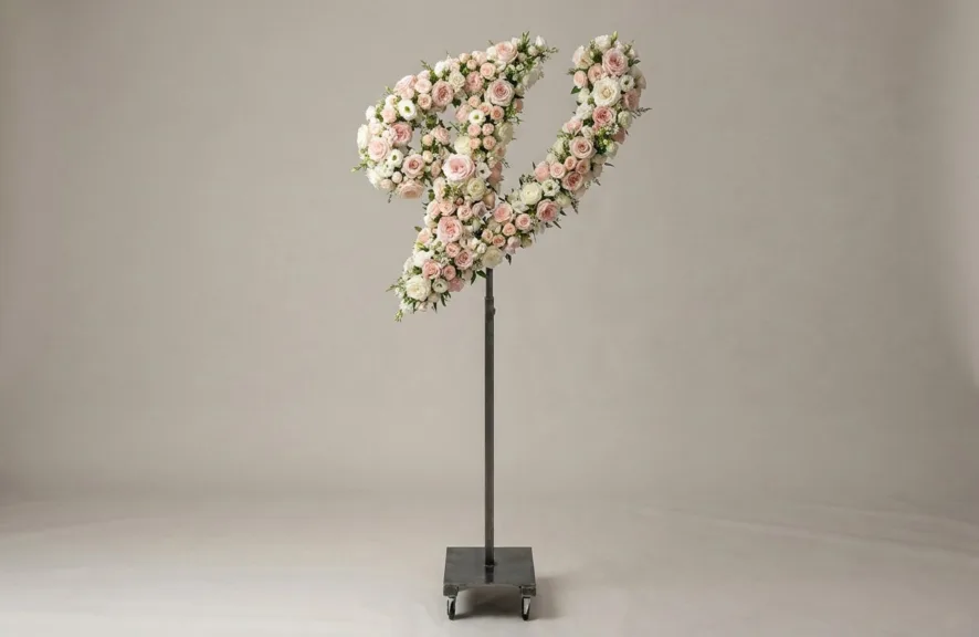 Monogram letter V topiary in script style, covered in pink and white roses