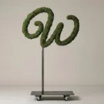 Monogram letter W topiary in Flowing script style, packed with green moss, on an adjustable stand