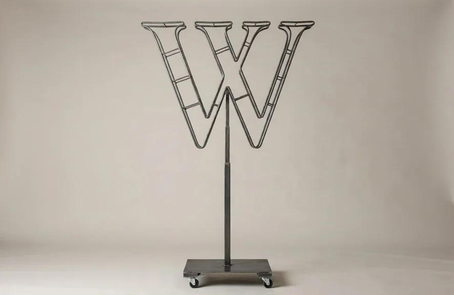 Monogram letter W topiary frame in Roman style, bare galvanized steel on an adjustable stand