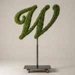 Monogram letter W topiary in Script style, packed with green moss, on an adjustable stand