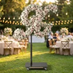 Monogram letter X topiary covered in flowers as a photo backdrop at a garden wedding
