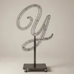Monogram letter Y topiary frame in Flowing script style, bare galvanized steel on an adjustable stand