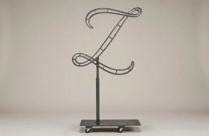 Monogram letter Z topiary frame in Flowing script style, bare galvanized steel on an adjustable stand